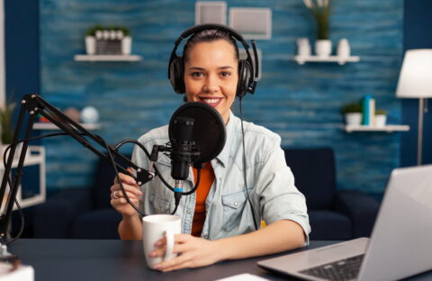 Influencer wearing headphones recording new podcast series at home studio for youtube channel.